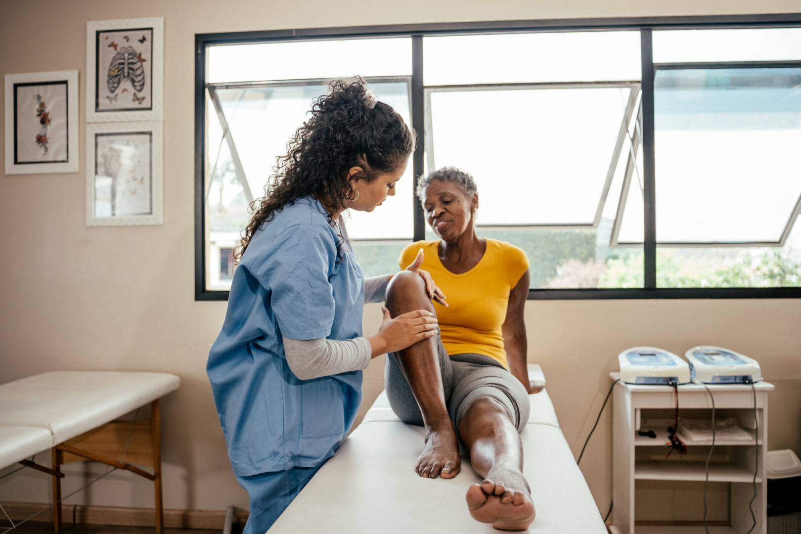 Healthcare provider examining patient's knee in clinic